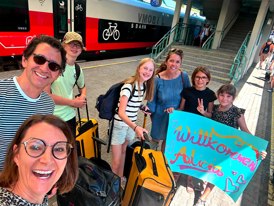 Familie begr&uuml;&szlig;t ein Austauschkind am Bahnhof mit einem Willkommensplakat